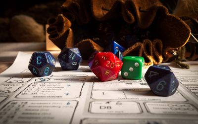 Close up of spilling out dice of different kinds from a dice bag on a character sheet.